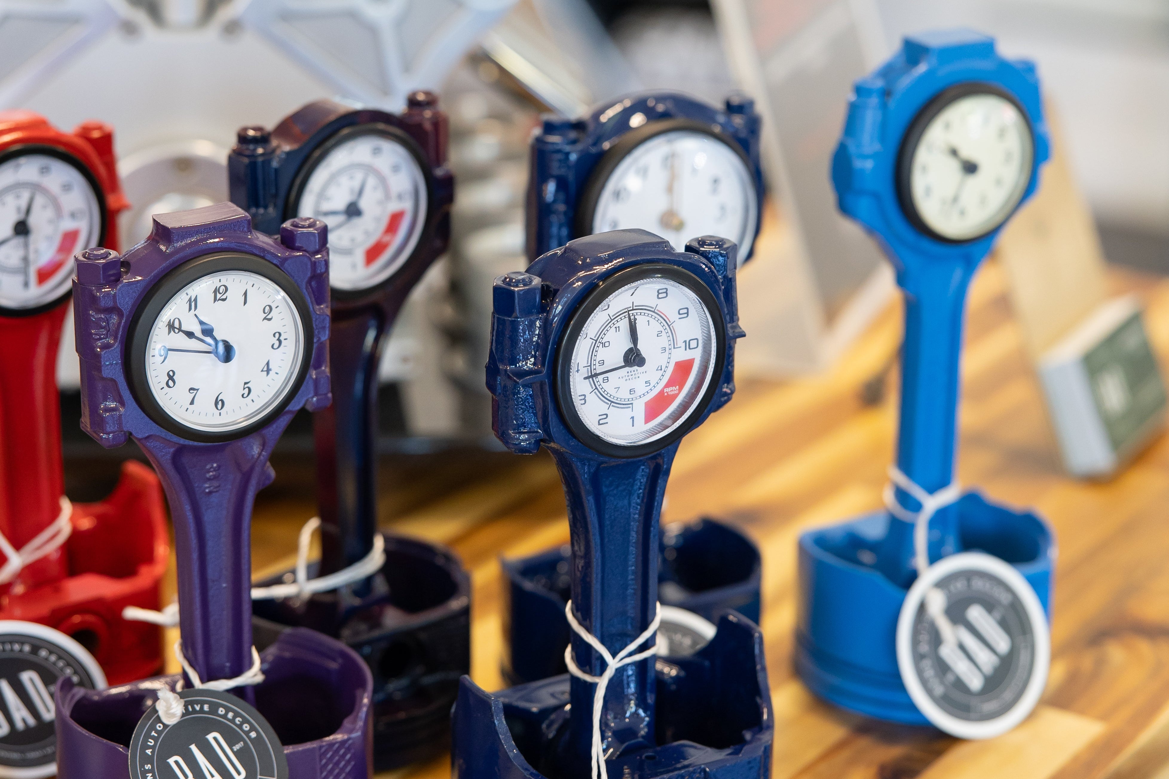 Decorative clocks shaped like wrenches on a wooden surface with a blurred background.