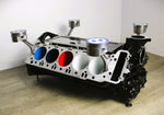 Load image into Gallery viewer, BMW M Series V10 engine block coffee table painted in the BMW M-Power color scheme without its glass top, the M-Power logo displayed across the piece, and the BMW logo on each of the four car pistons.
