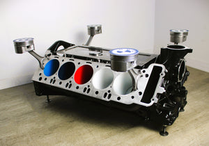 BMW M Series V10 engine block coffee table painted in the BMW M-Power color scheme without its glass top, the M-Power logo displayed across the piece, and the BMW logo on each of the four car pistons.