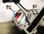 Load image into Gallery viewer, A close-up side view of a BMW M Series V10 engine block coffee table painted in the BMW M-Power color scheme without its glass top.

