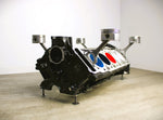 Load image into Gallery viewer, BMW M Series V10 engine block coffee table painted in the BMW M-Power color scheme without its glass top.
