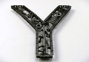 Close-up view of a letter Y made out of real car parts, outlined with a timing chain.