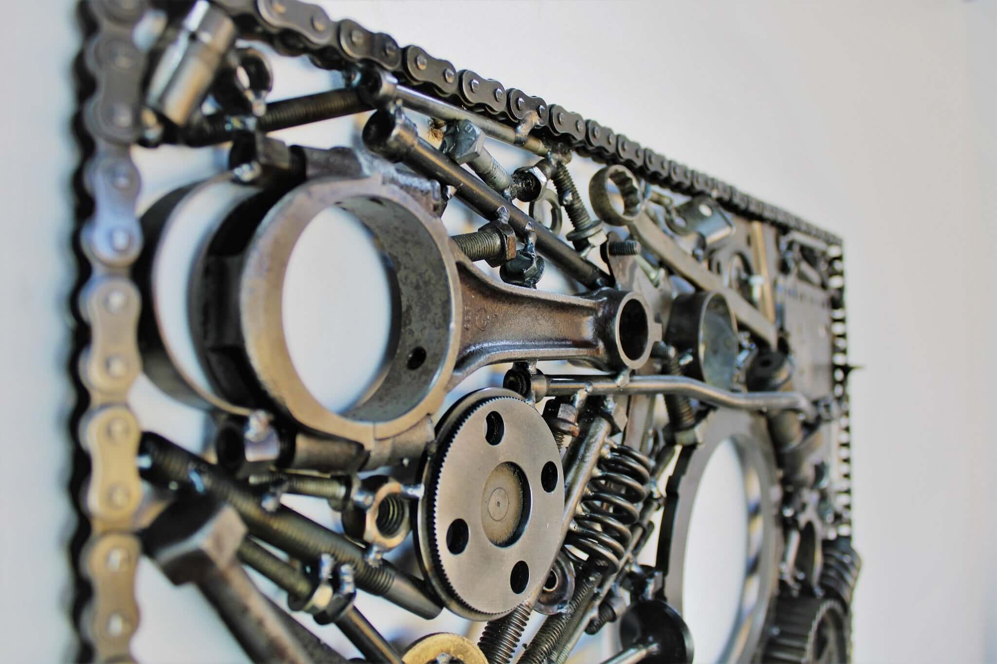 Handcrafted metal wall art piece outlined with timing chain and filled in entirely with polished genuine car engine components.