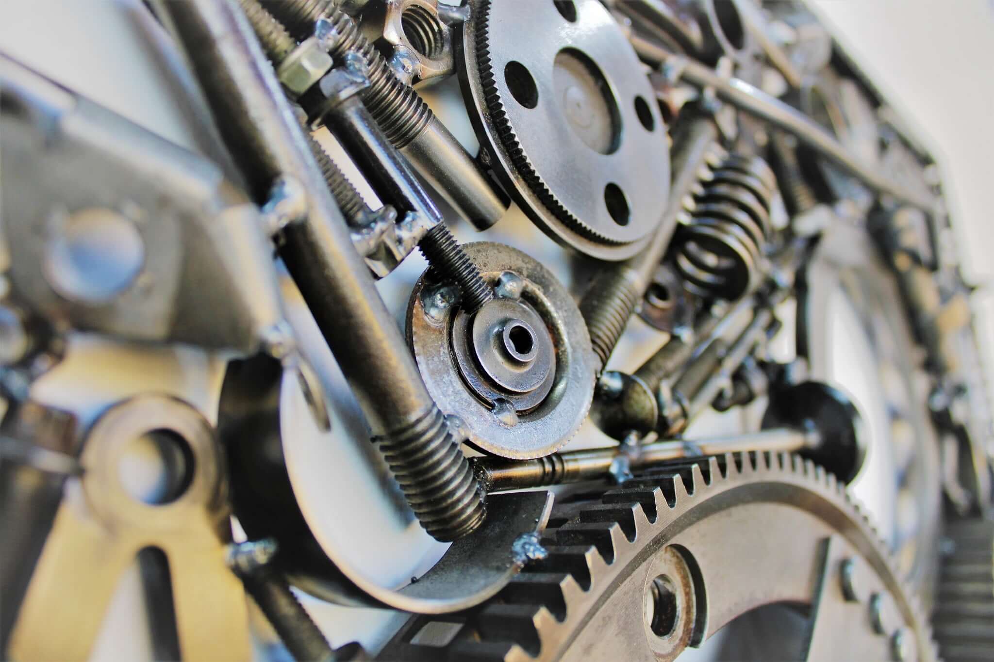 Handcrafted metal wall art piece outlined with timing chain and filled in entirely with polished genuine car engine components.