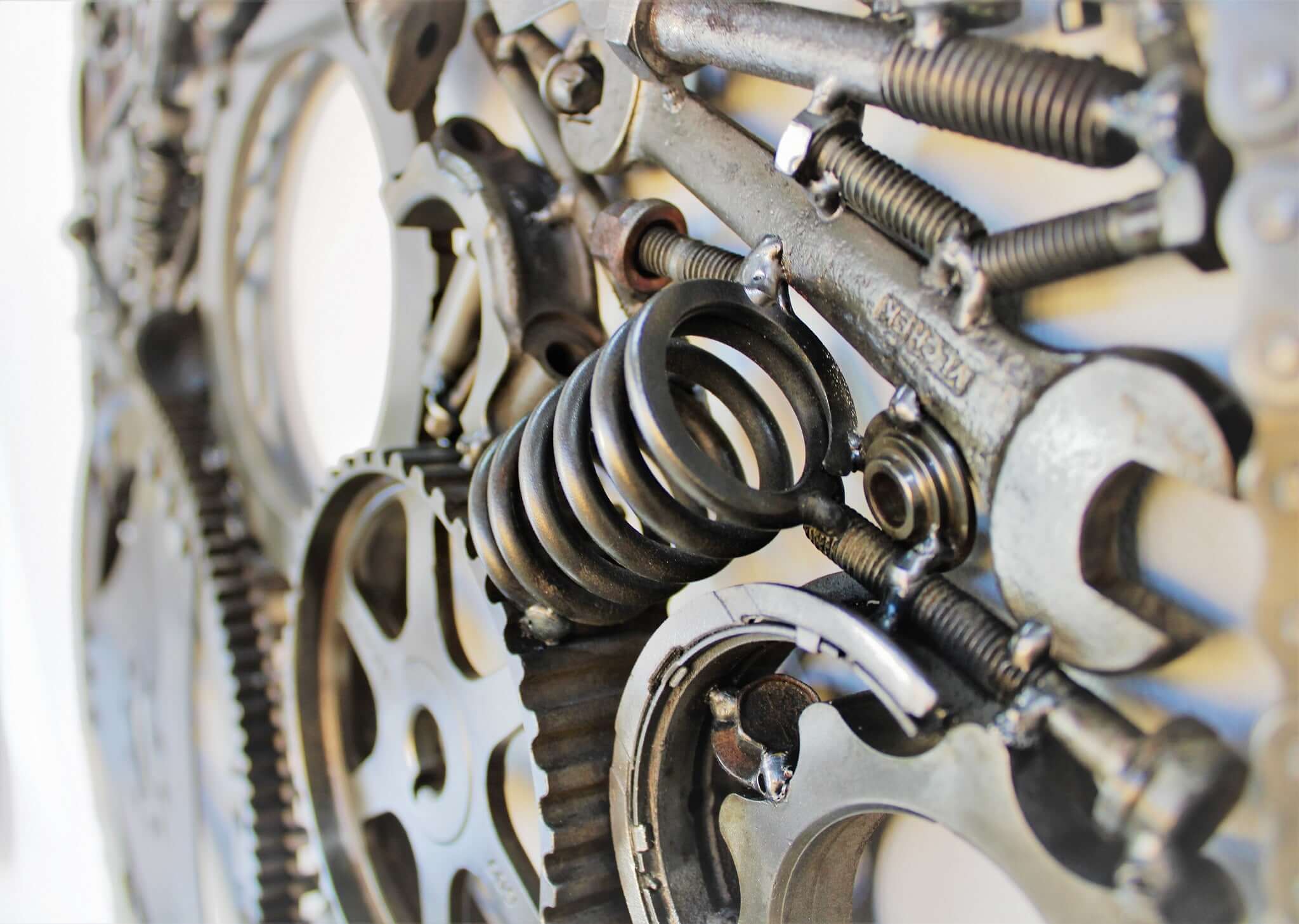 Handcrafted metal wall art piece outlined with timing chain and filled in entirely with polished genuine car engine components.