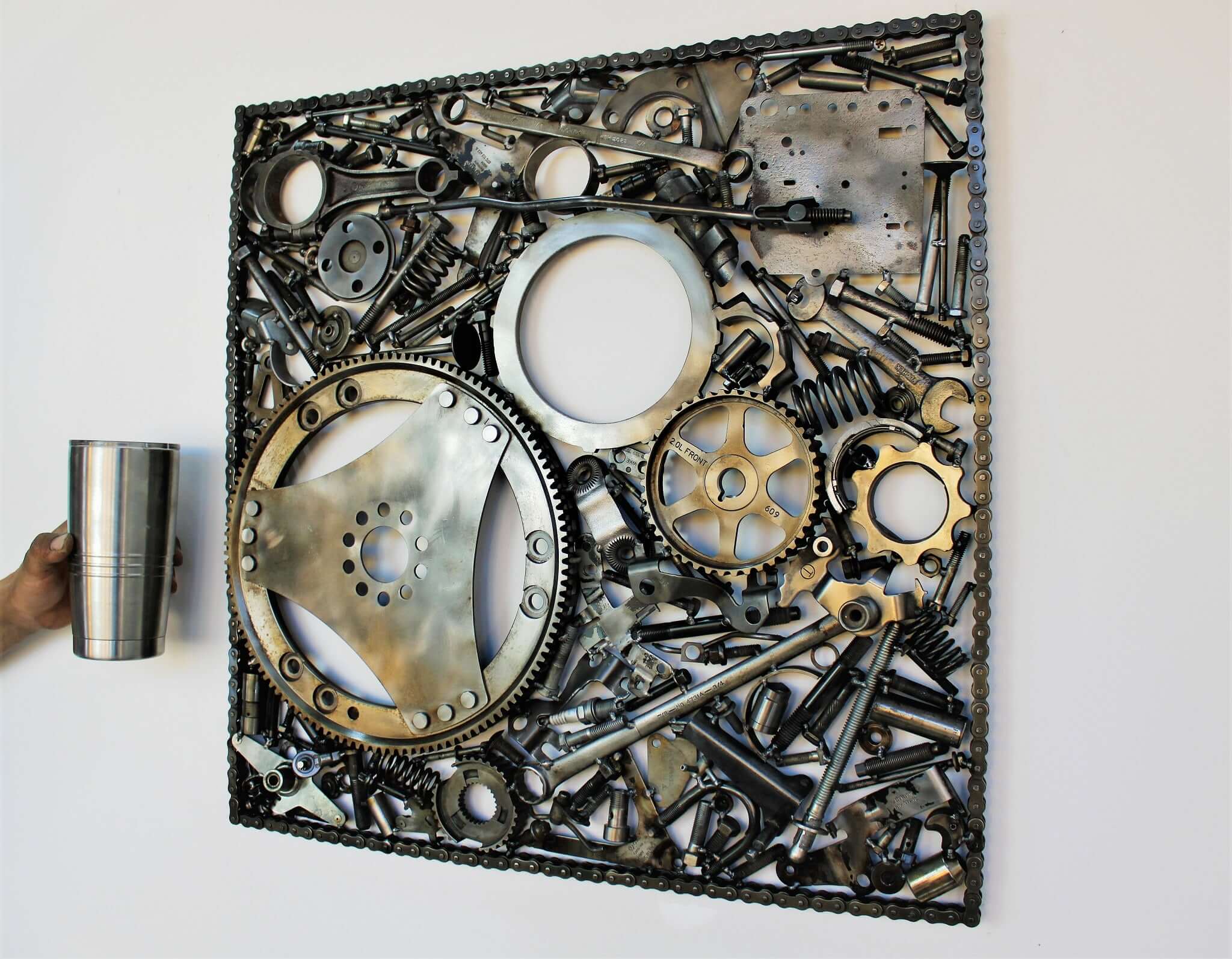 Handcrafted metal wall art piece outlined with timing chain and filled in entirely with polished genuine car engine components.