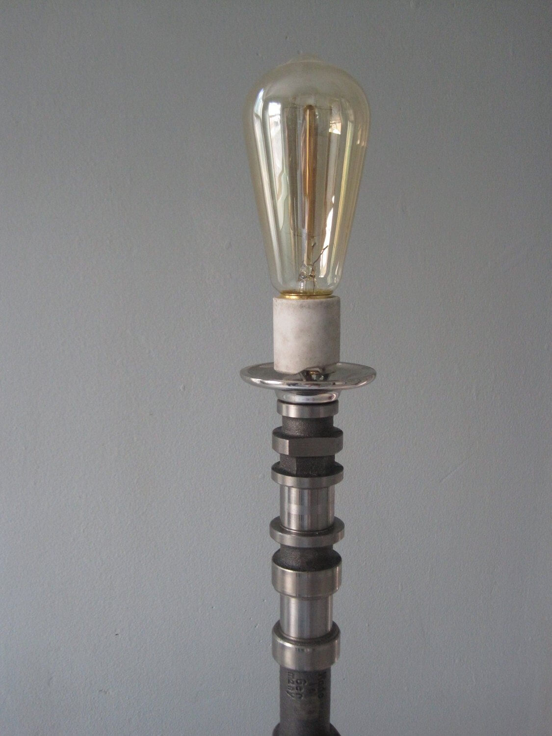Tabletop lamp handcrafted from a genuine polished car engine camshaft with a LED lightbulb.