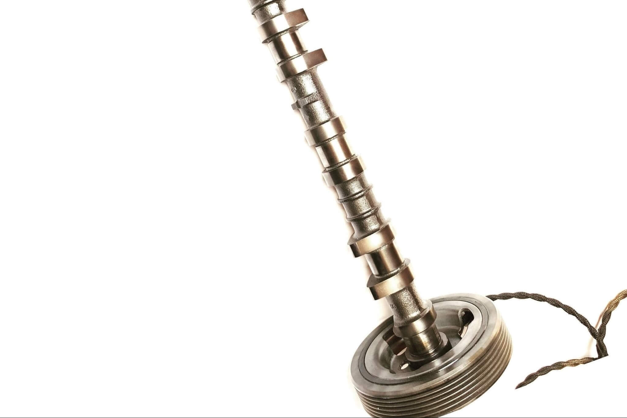 Tabletop lamp handcrafted from a genuine polished car engine camshaft with a LED lightbulb and white shade.