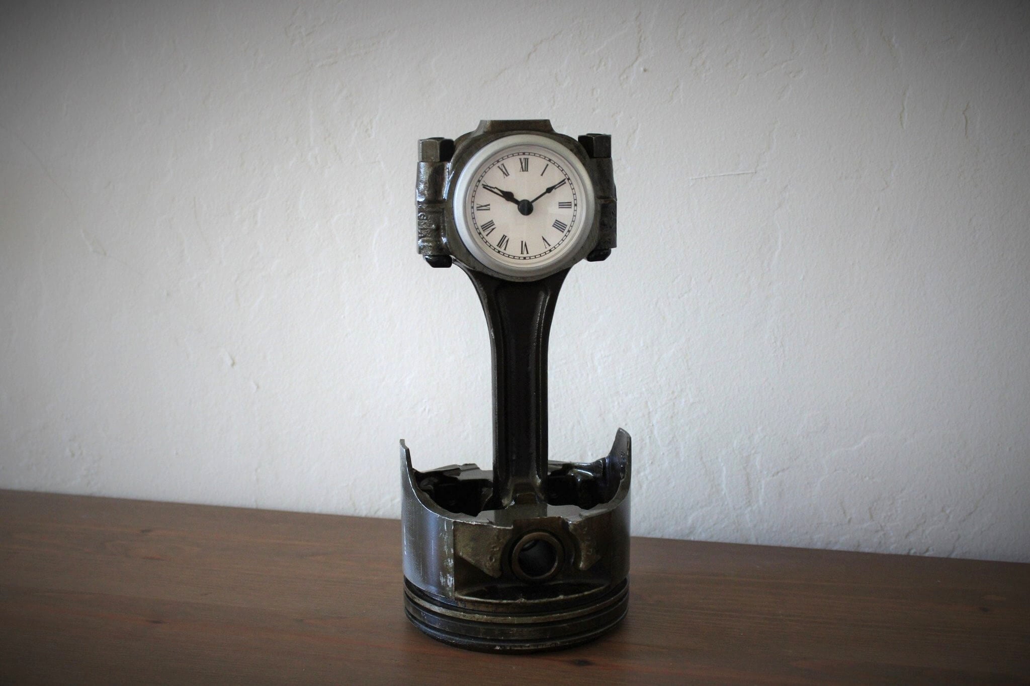 Tabletop clock handcrafted from a genuine Chevrolet car engine piston with various colored finishes and a standard clock face.