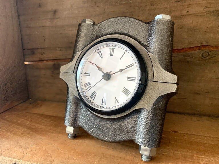 Tabletop clock handcrafted from a genuine polished car engine crankshaft cap with a patina finish and black and white roman numeral clock face.