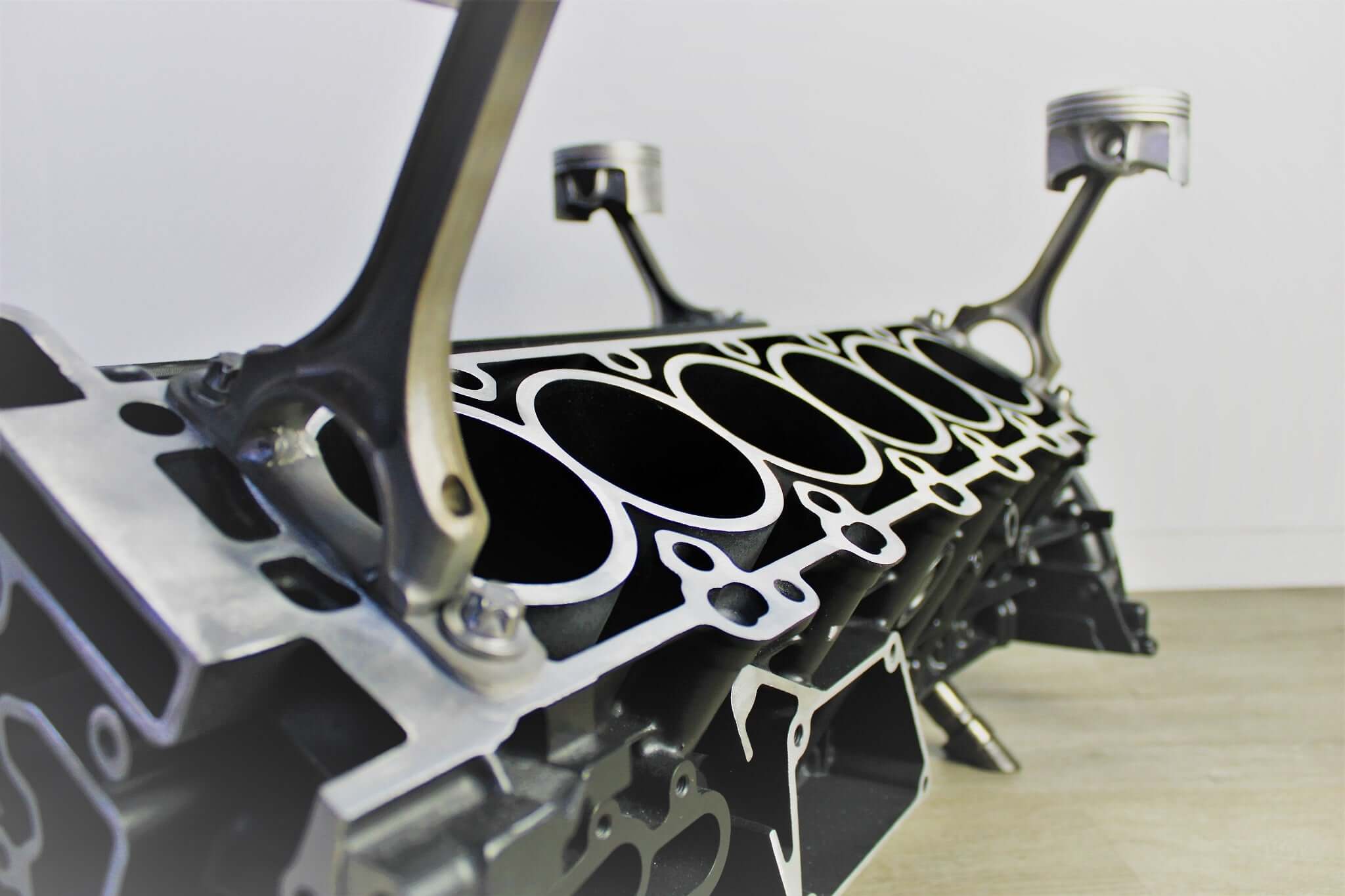 Coffee table handcrafted from a genuine Mercedes V12 car engine, finished in black and silver with the Mercedes logo displayed and a rectangular glass top.