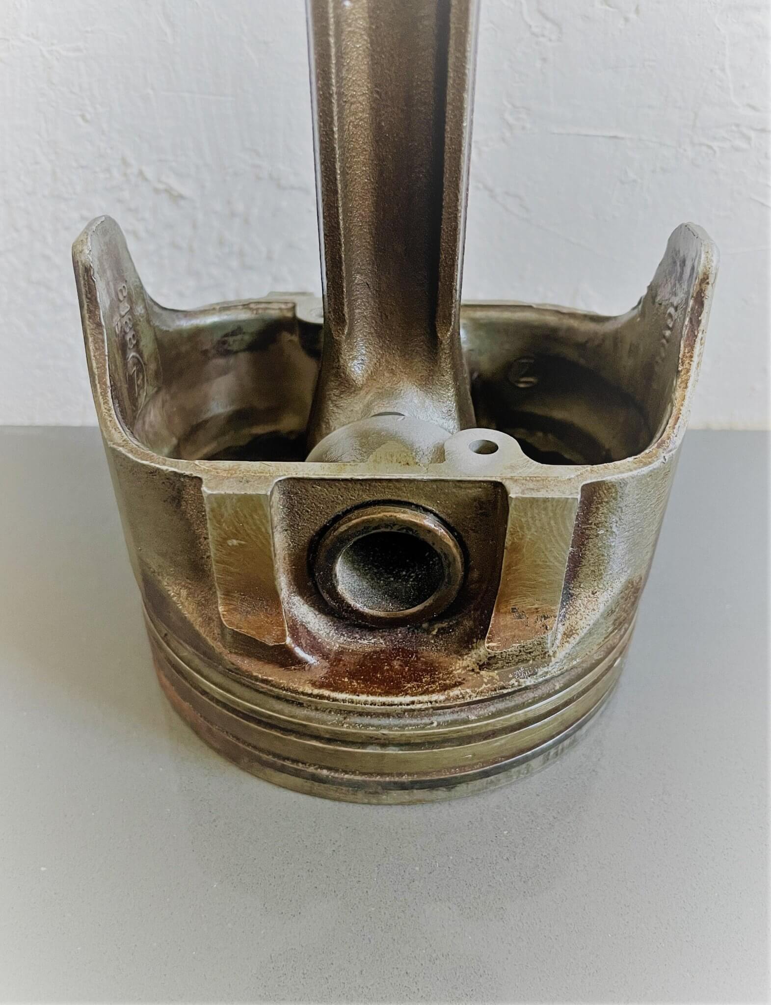 Tabletop clock handcrafted from a genuine car engine piston with a black and red clock face emulating a race car dashboard.