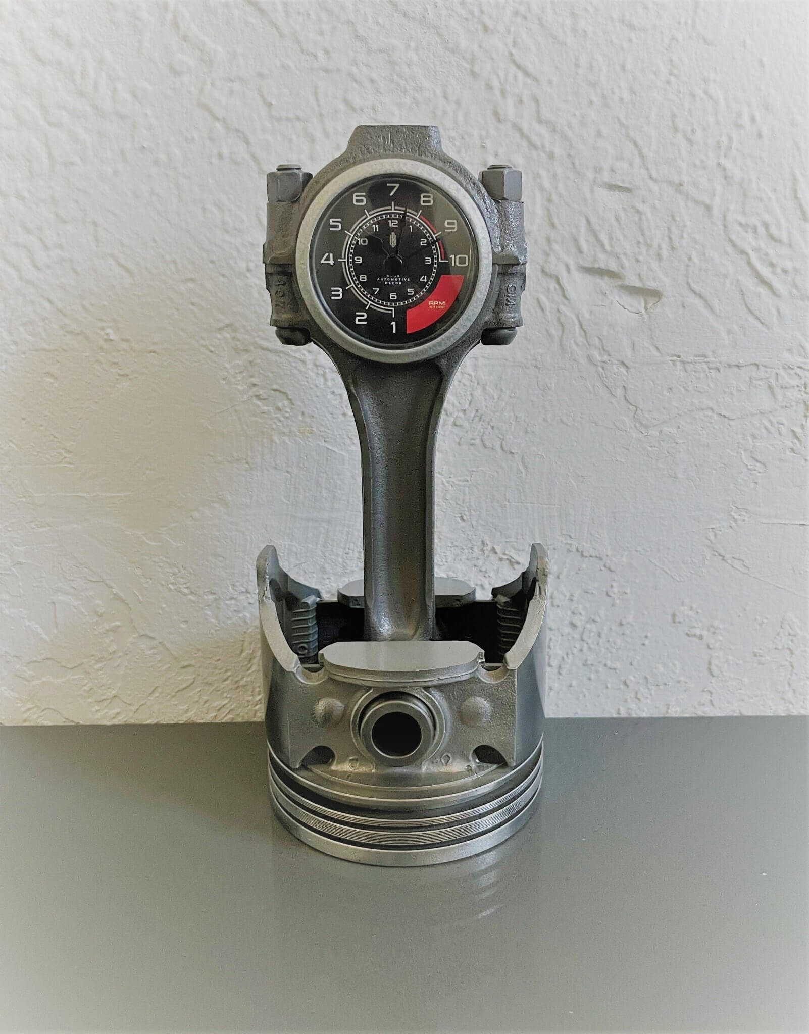 Tabletop clock handcrafted from a genuine car engine piston with a black and red clock face emulating a race car dashboard.