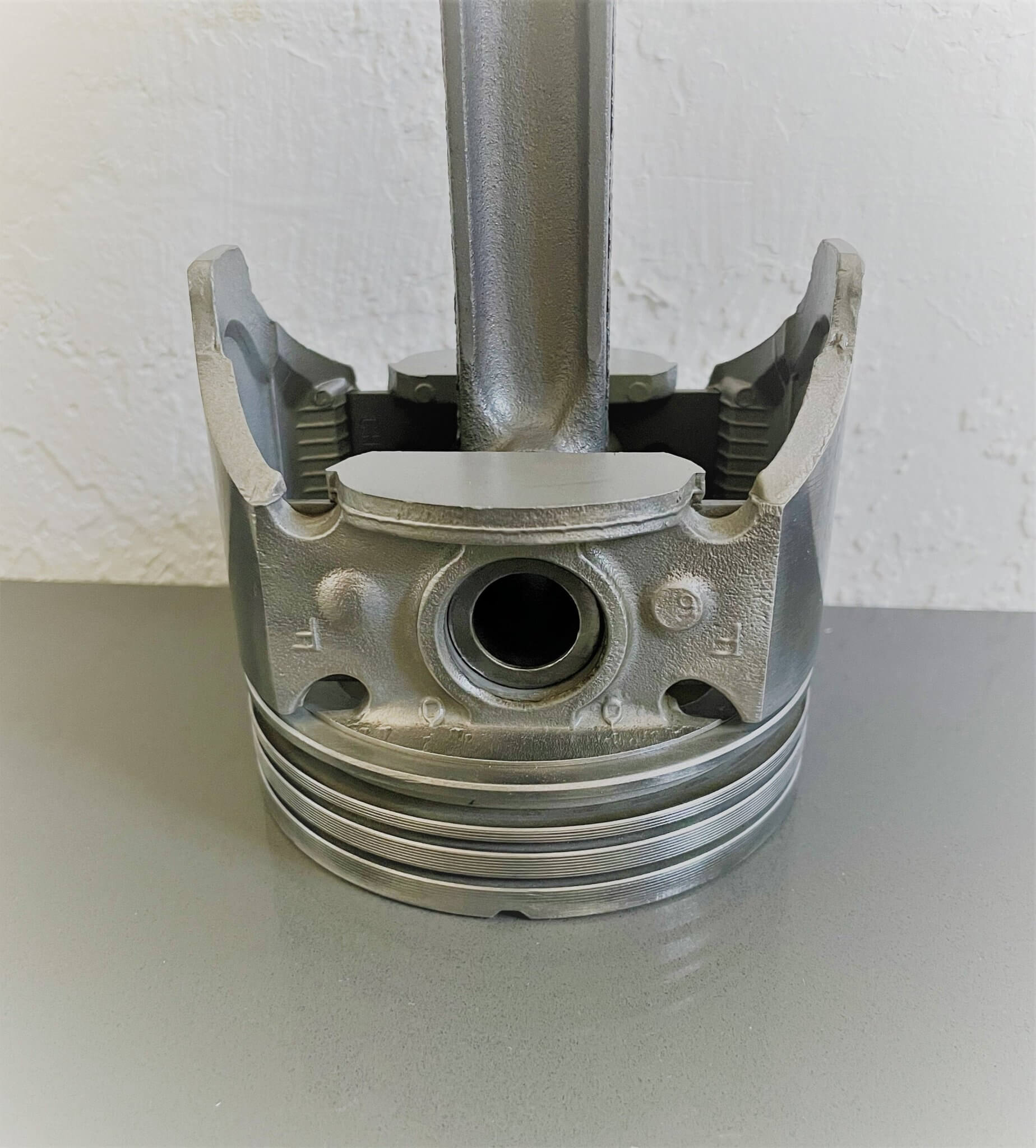 Tabletop clock handcrafted from a genuine car engine piston with a black and red clock face emulating a race car dashboard.