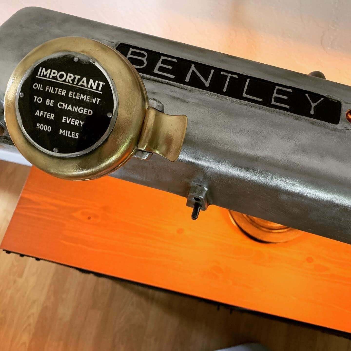 Tabletop lamp handcrafted from a genuine polished car valve cover, with an engraved cap, the Bentley logo displayed and LED lightbulbs.