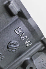 Load image into Gallery viewer, Close-up of the BMW logo on a BMW end table and wine rack finished in gunmetal grey.
