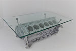 Load image into Gallery viewer, Engine block coffee table painted light gray, with its rectangular glass top being held up by car engine pistons.

