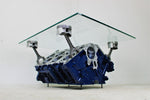 Load image into Gallery viewer, Bentley engine block coffee table with a rectangular glass top held up by car engine pistons. The table is painted dark blue, with the Bentley logo displayed on the front.
