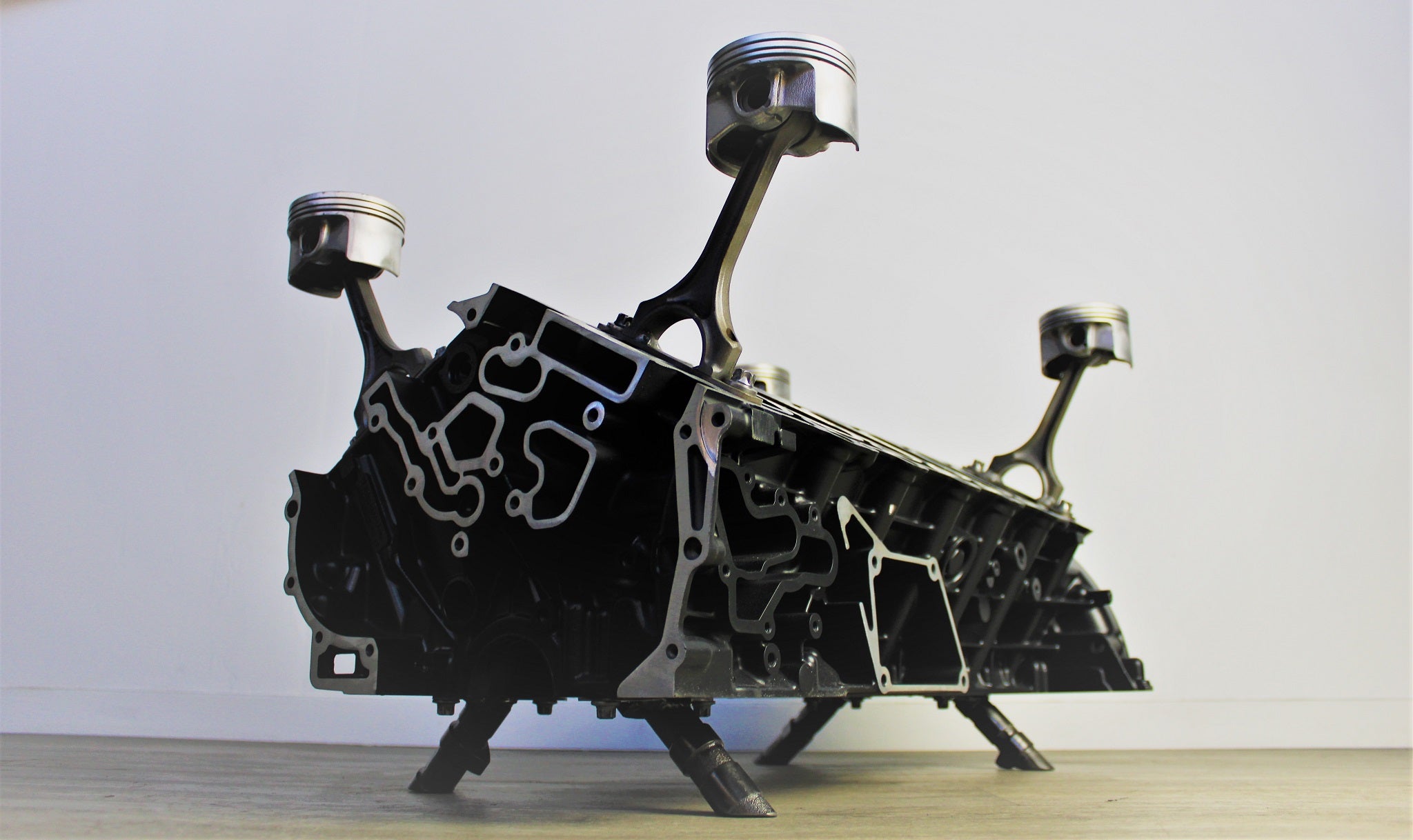 Mercedes V12 engine block coffee table finished in black and silver without its glass top.