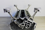 Load image into Gallery viewer, Mercedes V12 engine block coffee table, finished in black and silver without its glass top.
