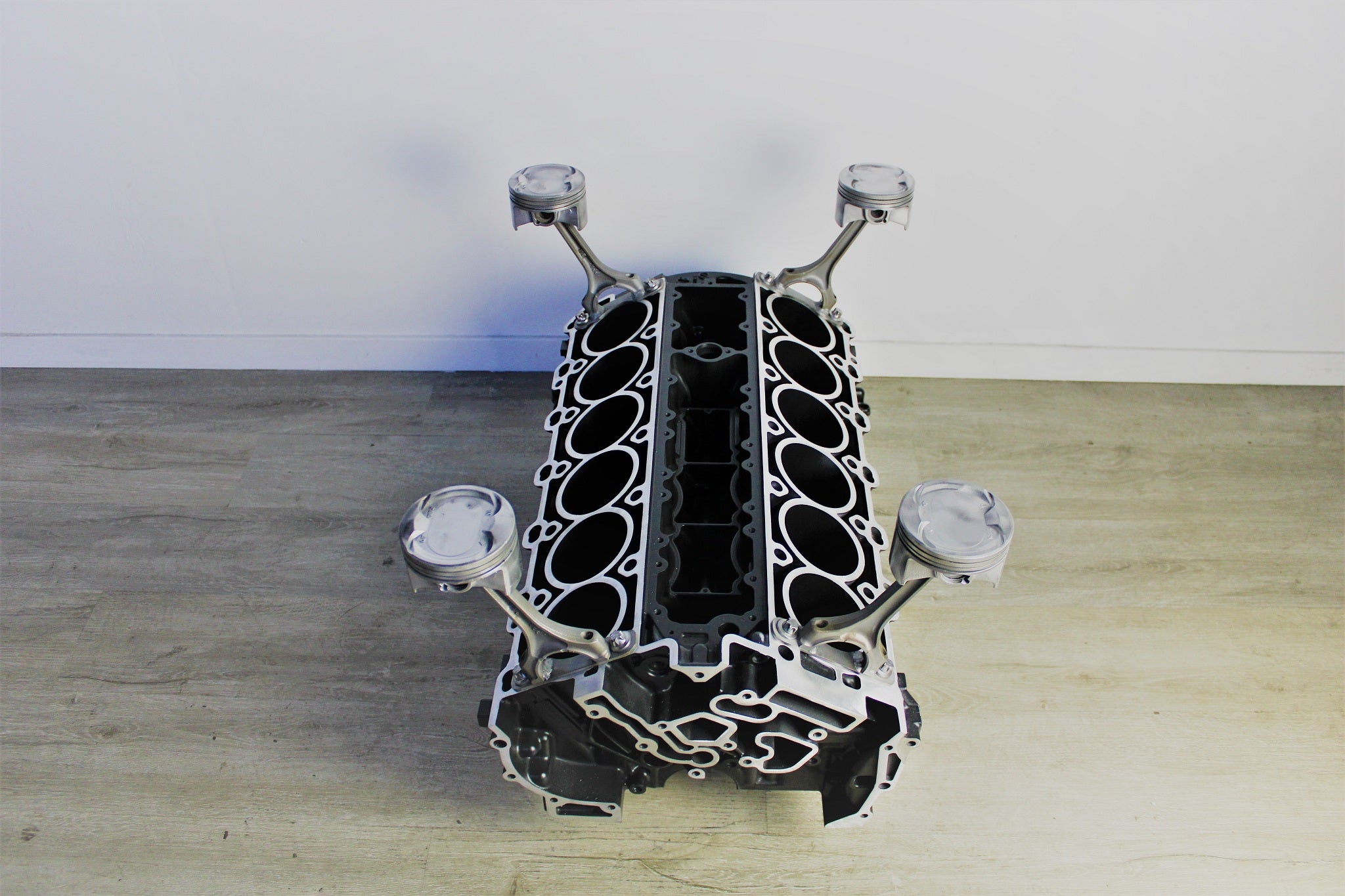 Birds-eye view of a Mercedes V12 engine block coffee table, finished in black and silver without its glass top.