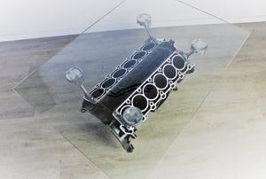 Birds-eye view of a Mercedes V12 engine block coffee table, finished in black and silver with a rectangular glass top.