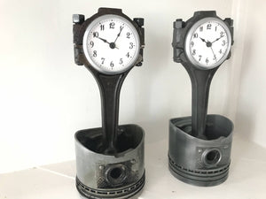 Two car piston clocks - left clock has a patina finish with a silver clock ring, and right clock has an elegant finish with a silver clock ring.