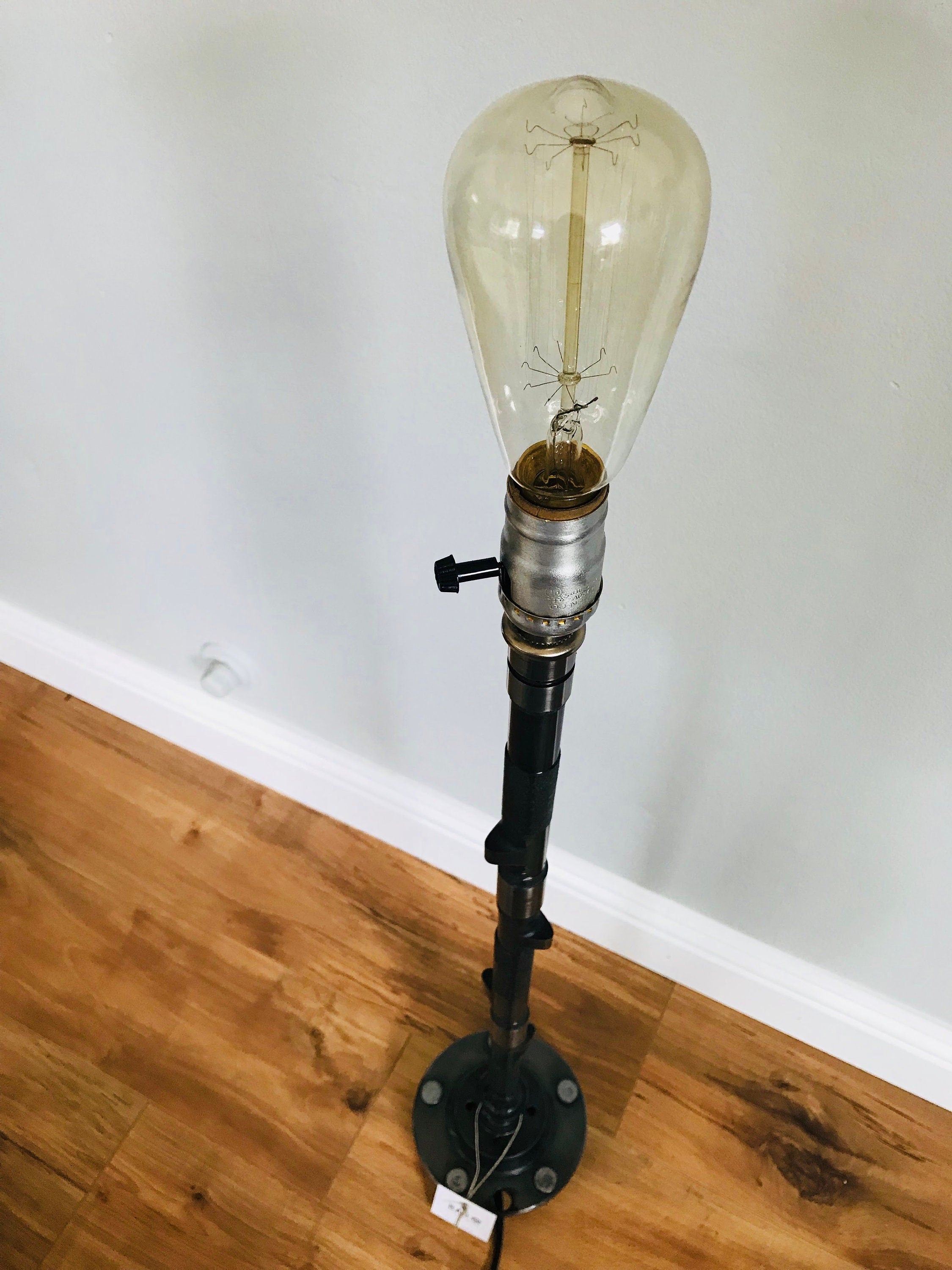 Lamp made out of a car's camshaft without its shade.