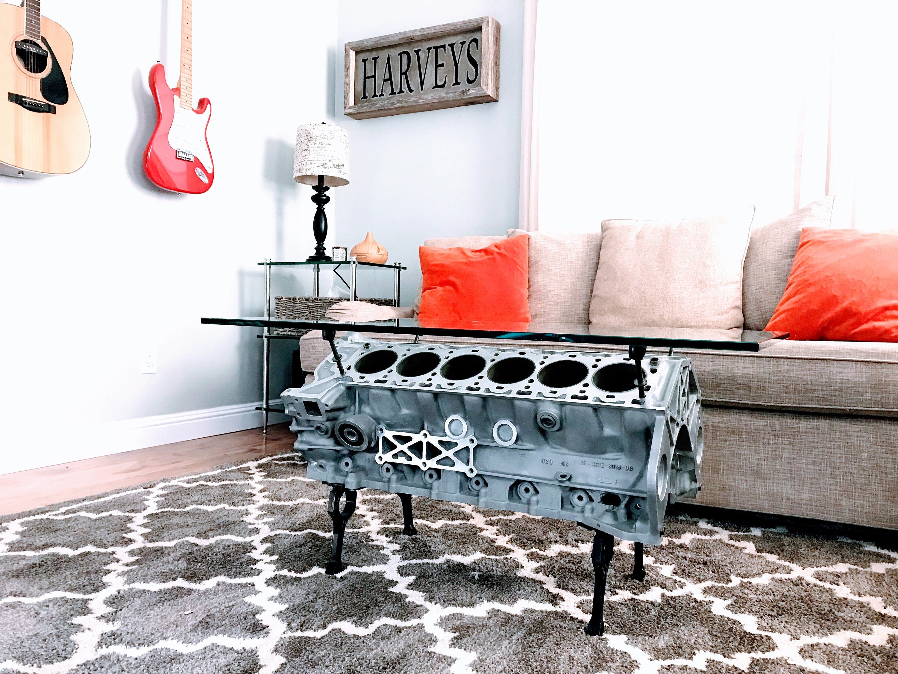 An engine block coffee table, finished in gray, displayed in a living room on a grey rug.