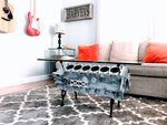 Load image into Gallery viewer, An engine block coffee table, finished in gray, displayed in a living room on a grey rug.
