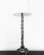 Load image into Gallery viewer, Silver lamp made out of a car&#39;s camshaft with its shade.

