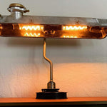 Load image into Gallery viewer, Desk lamp made from a car&#39;s valve cover turned on.
