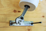 Load image into Gallery viewer, Wrench and nut toilet paper holder being turned to change its toilet paper roll.
