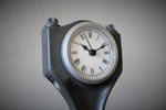 Load image into Gallery viewer, Close-up view of a clock made out of a car engine&#39;s piston, finished in gunmetal gray with a silver clock ring.
