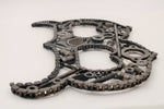 Load image into Gallery viewer, Close-up view of a letter B made out of car parts and outlined with timing chain.

