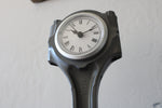 Load image into Gallery viewer, Close-up view of a clock made out of a car engine&#39;s piston finished in gunmetal gray with a silver clock ring.
