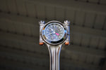 Load image into Gallery viewer, Close-up view of a piston clock made out of a Jaguar E-type XKE car piston, finished in gunmetal gray with a silver clock ring.
