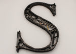 Load image into Gallery viewer, A letter S made out of real car parts, outlined with a car&#39;s timing chain.

