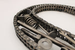 Load image into Gallery viewer, Close-up view of a letter decoration made out of car parts and outlined with timing chain.
