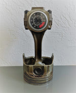 Load image into Gallery viewer, A car piston clock in a patina finish with a silver clock ring and a black and red RPM clock face.
