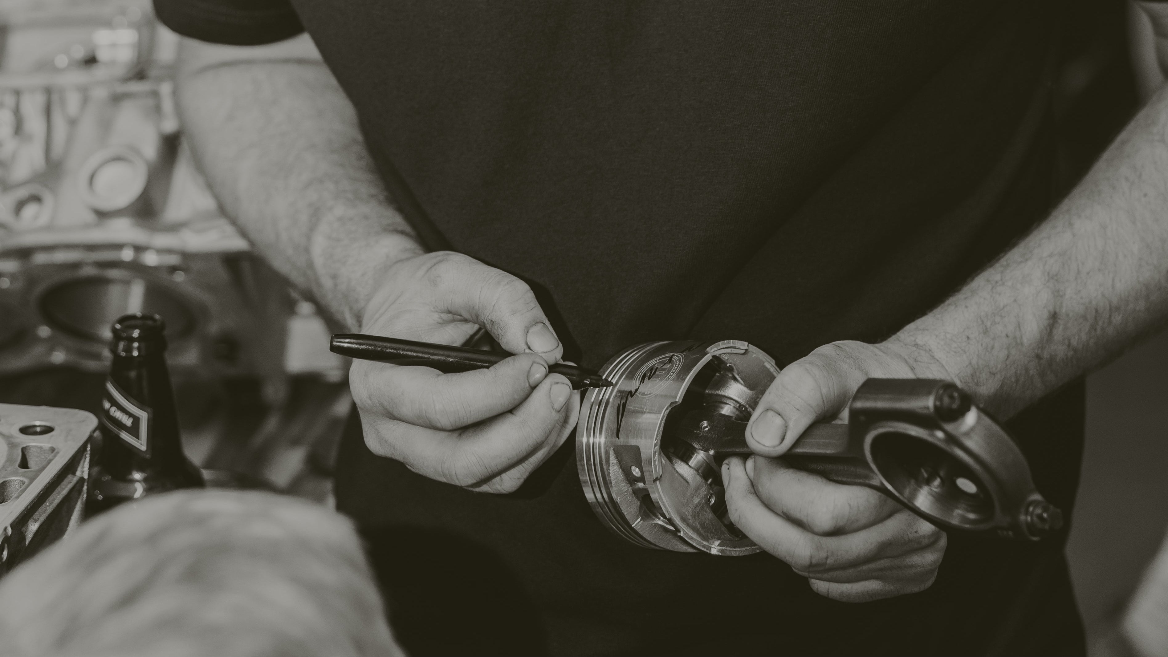 Man wearing a black t-shirt with 'BAD' printed on it, working on something.