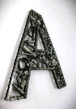 Load image into Gallery viewer, A letter A made out of real car parts, outlined with a timing chain.
