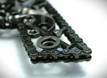Load image into Gallery viewer, Close-up view of a letter A made out of real car parts, outlined with a timing chain.
