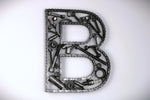 Load image into Gallery viewer, A letter B made out of real car parts, outlined with a timing chain.
