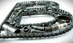 Load image into Gallery viewer, Close-up view of a letter B made out of real car parts, outlined with a timing chain.
