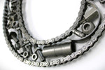 Load image into Gallery viewer, Close-up view of a letter C made out of real car parts, outlined with a timing chain.
