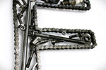 Load image into Gallery viewer, Close-up view of a letter E made out of real car parts, outlined with a timing chain.
