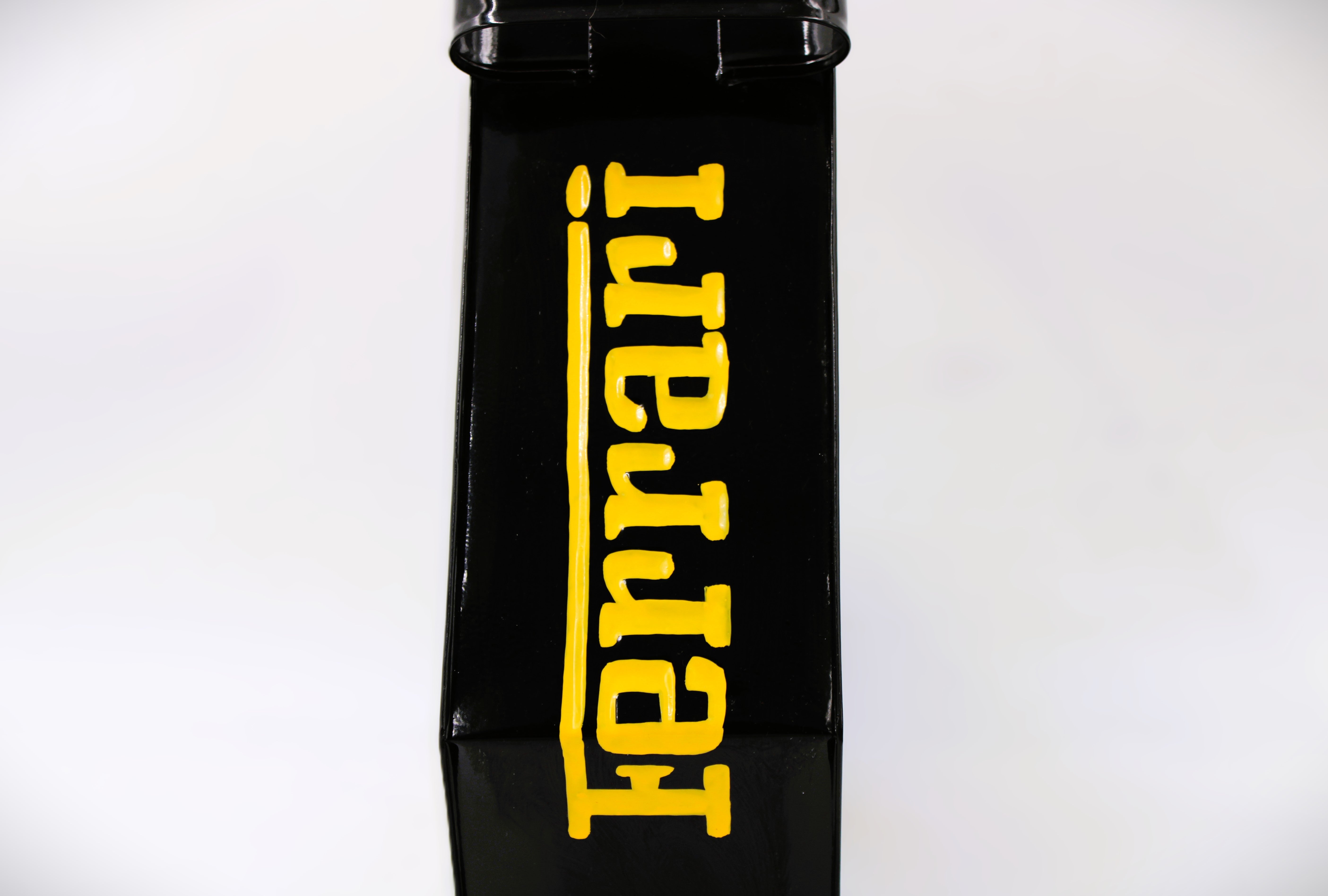 Side view of a black and yellow painted gas can with the Ferrari logo displayed.