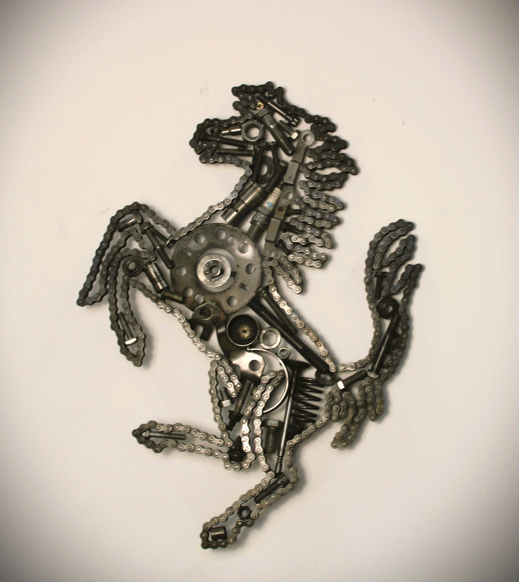 Ferrari prancing horse logo art piece, made out of car parts and outlined with a timing chain.