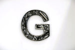 Load image into Gallery viewer, A letter G made out of real car parts, outlined with a timing chain.
